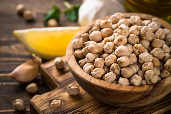 Chickpeas in bowl at light kitchen table.